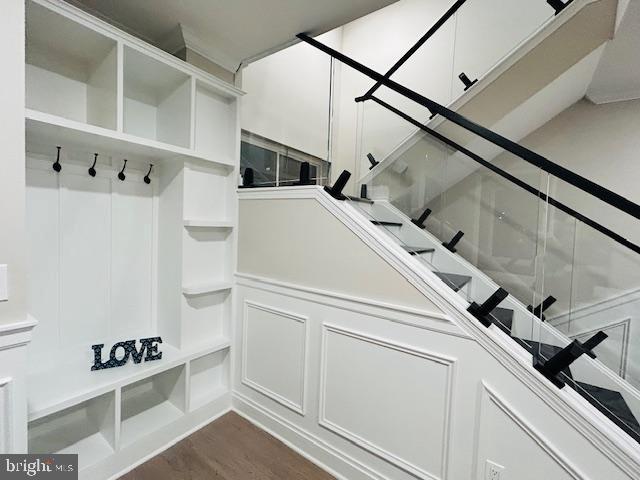 mudroom featuring a decorative wall and dark wood-style flooring