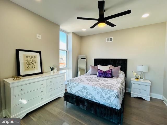 bedroom with dark wood-style floors, visible vents, baseboards, and recessed lighting