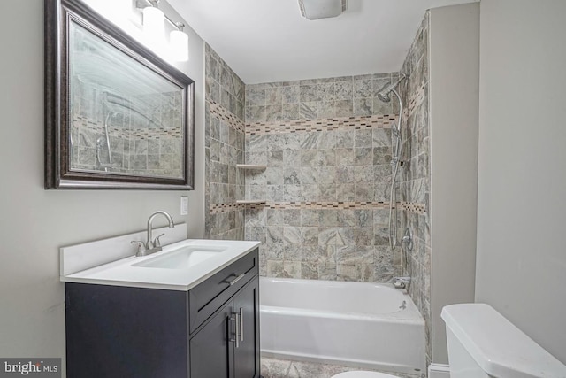 full bathroom with vanity, tiled shower / bath combo, and toilet