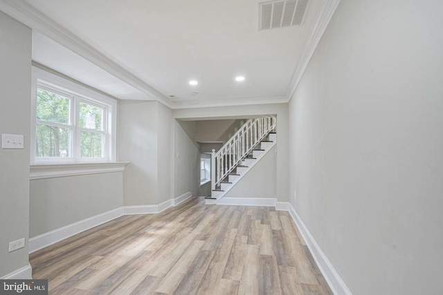 spare room with ornamental molding and light hardwood / wood-style flooring