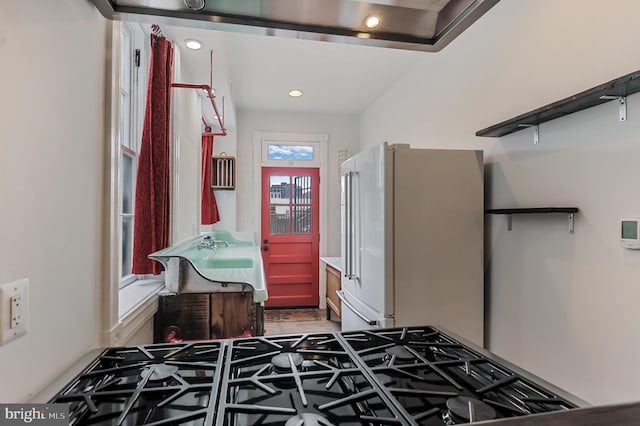 kitchen with high end white fridge and range with gas cooktop