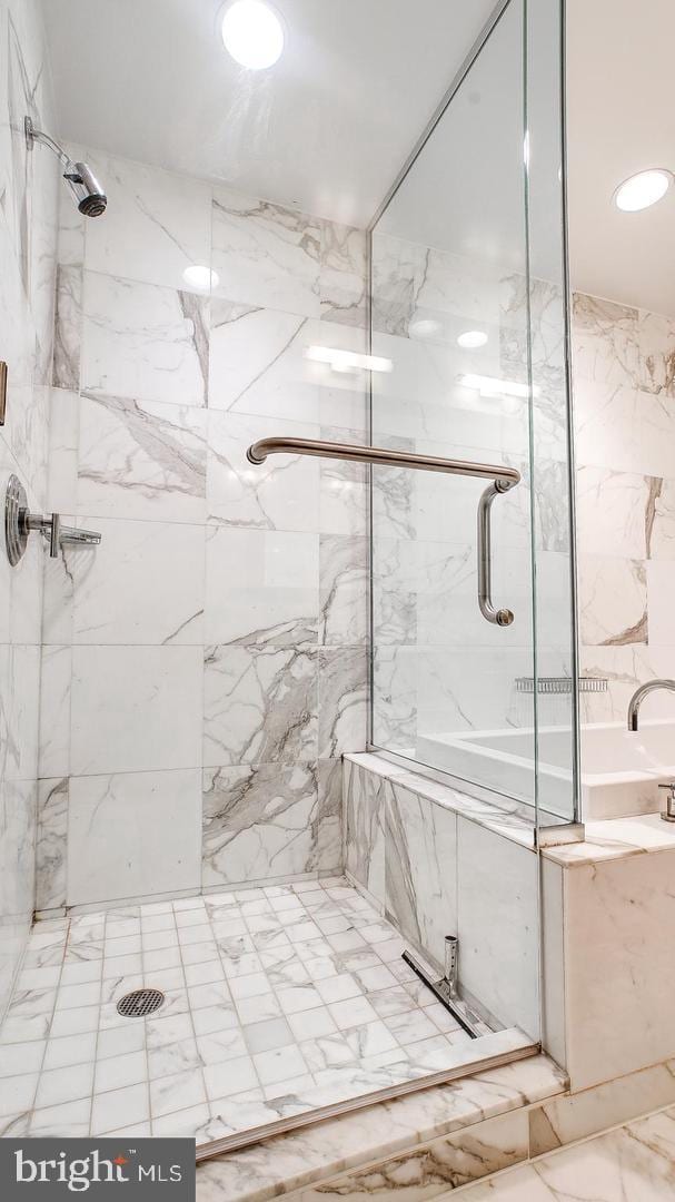 bathroom featuring a marble finish shower