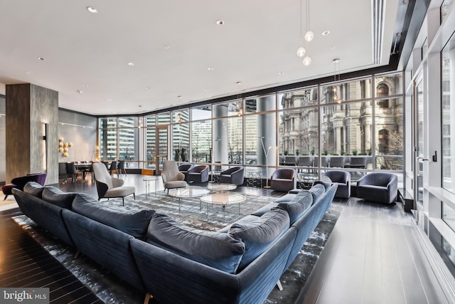 living room with a wall of windows, a view of city, recessed lighting, and wood finished floors