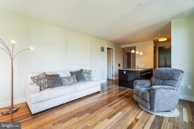 living room featuring dark wood-type flooring, visible vents, and baseboards