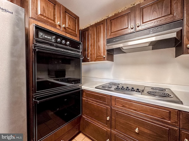 kitchen featuring electric cooktop, double oven, and stainless steel fridge