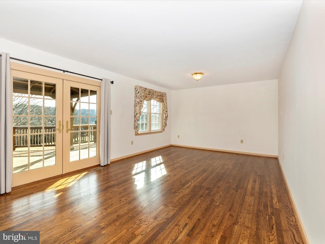 unfurnished room with baseboards, dark wood finished floors, and french doors