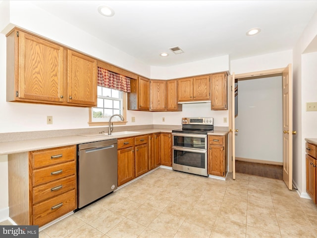 kitchen with stainless steel appliances, recessed lighting, and light countertops