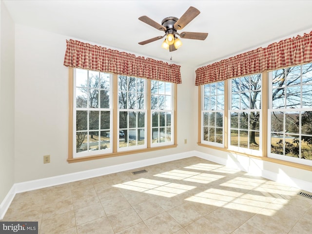 unfurnished sunroom with visible vents and ceiling fan