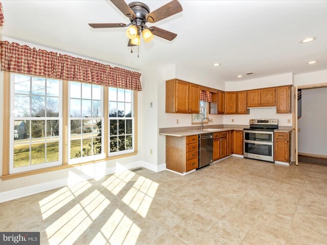 kitchen with brown cabinets, stainless steel appliances, recessed lighting, light countertops, and baseboards