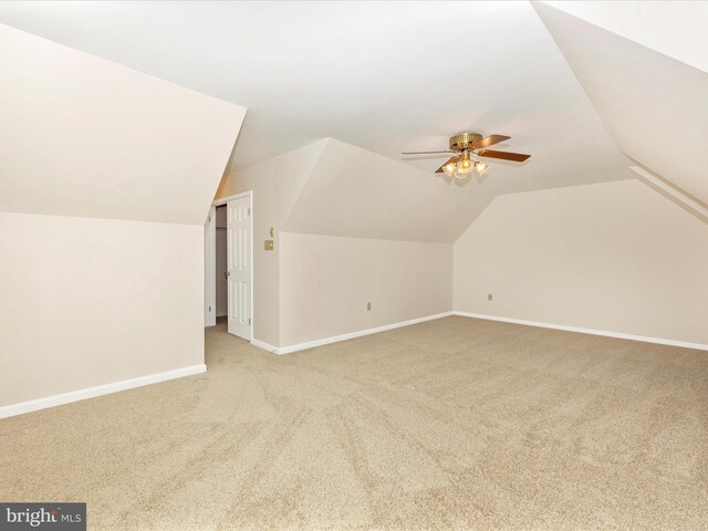 bonus room with light colored carpet, vaulted ceiling, baseboards, and ceiling fan