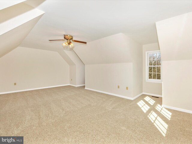 additional living space featuring visible vents, lofted ceiling, light colored carpet, and baseboards