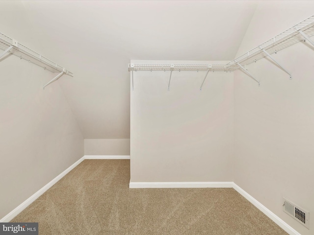 walk in closet featuring vaulted ceiling, carpet, and visible vents