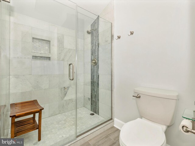 bathroom with a shower stall and toilet