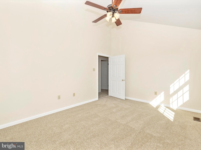 spare room with light carpet, high vaulted ceiling, visible vents, and baseboards