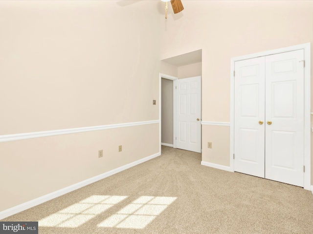 unfurnished bedroom with a ceiling fan, a closet, carpet flooring, and baseboards