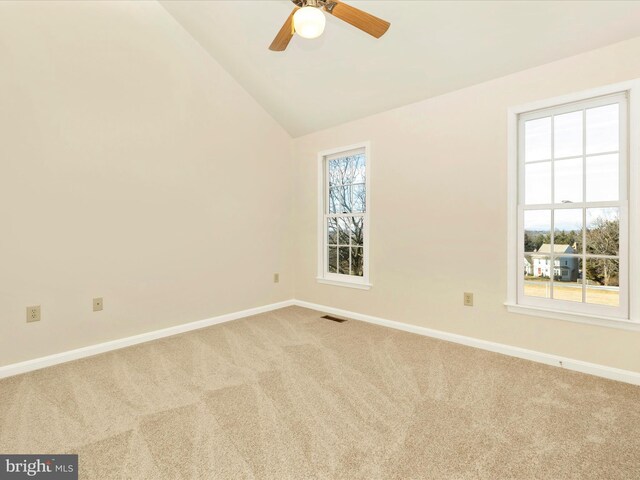 unfurnished room featuring lofted ceiling, carpet, visible vents, and baseboards