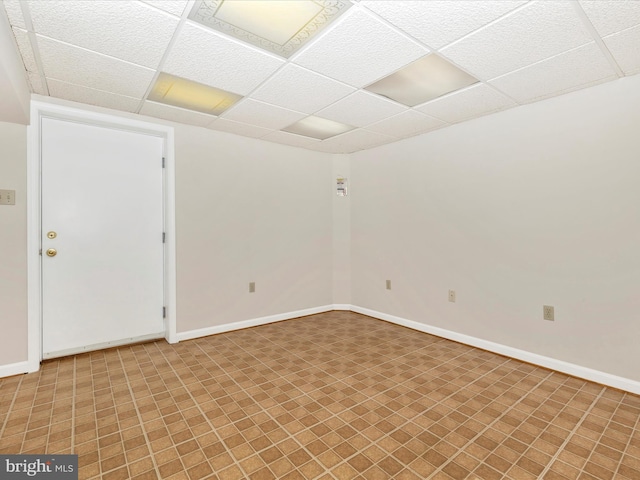 empty room with a drop ceiling and baseboards