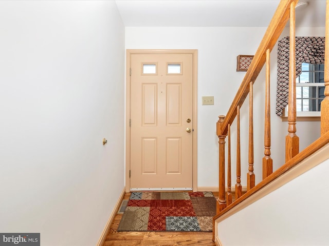 foyer entrance featuring a healthy amount of sunlight, baseboards, visible vents, and stairway