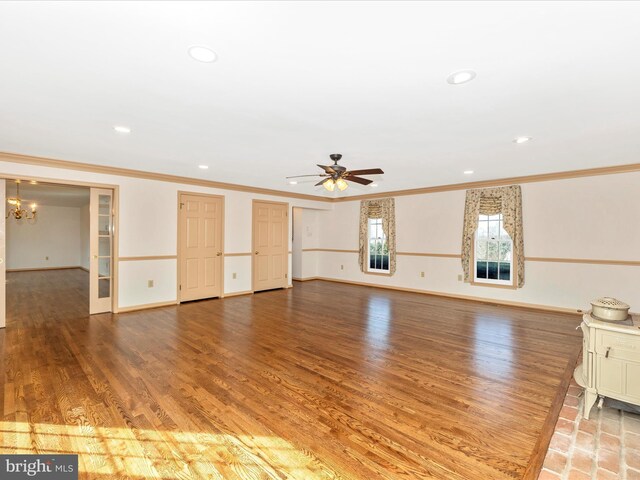 unfurnished living room featuring baseboards, wood finished floors, ceiling fan with notable chandelier, crown molding, and recessed lighting