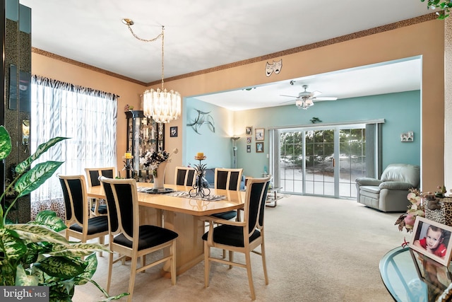 dining area with light carpet, crown molding, and ceiling fan with notable chandelier