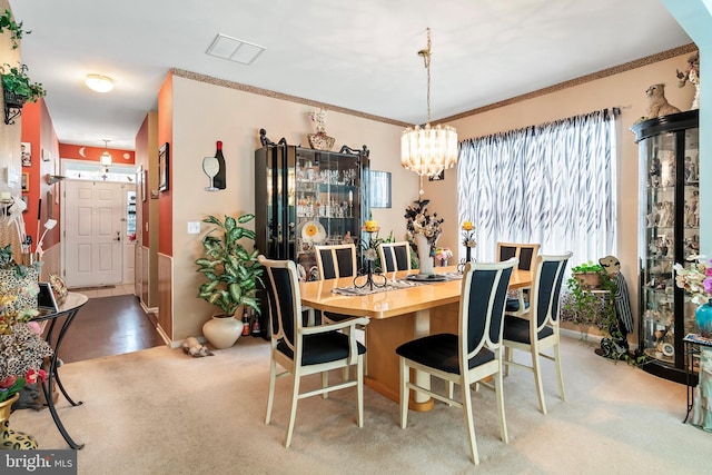 dining area with a notable chandelier and crown molding