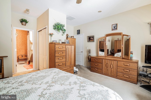 carpeted bedroom featuring connected bathroom, ceiling fan, and a closet