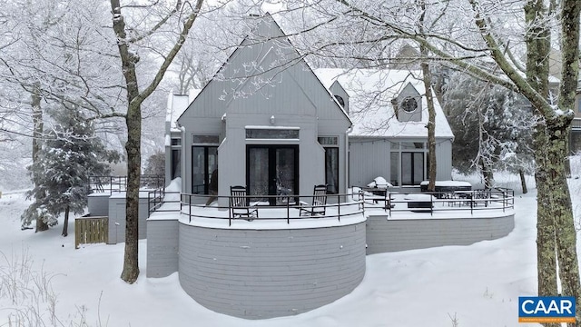 view of snow covered back of property