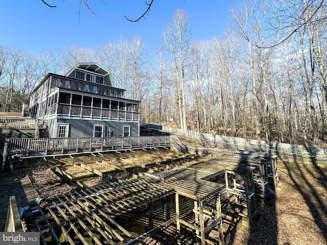 back of property featuring a balcony and fence