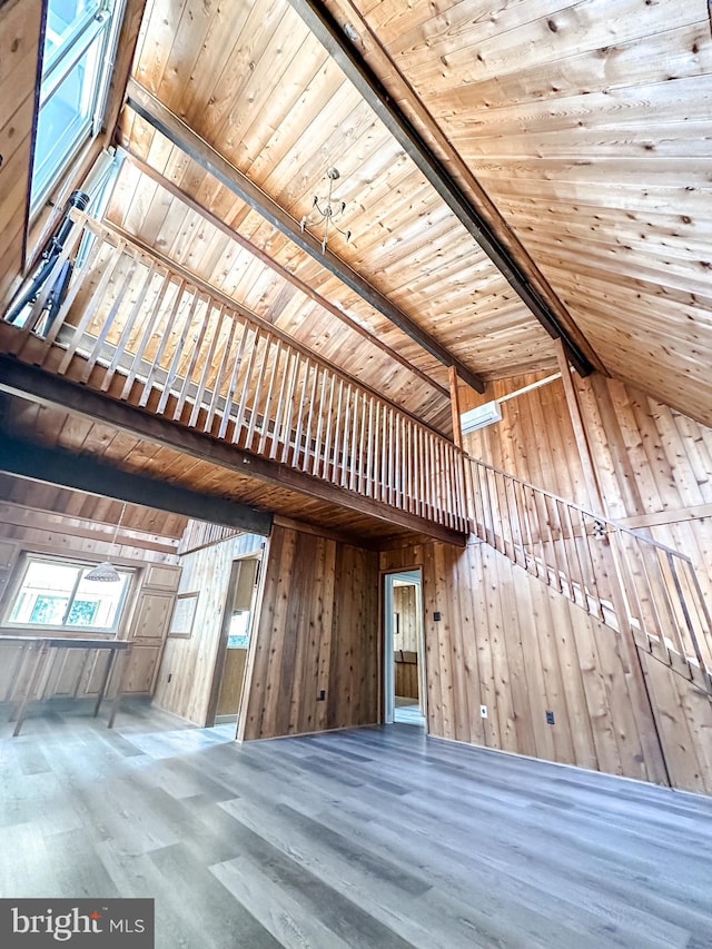 interior space featuring vaulted ceiling with beams, wood ceiling, wooden walls, and wood finished floors