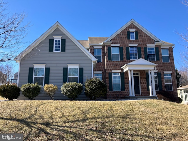 view of front of home with brick siding and a front lawn