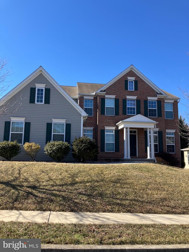 view of front of property with brick siding and a front lawn