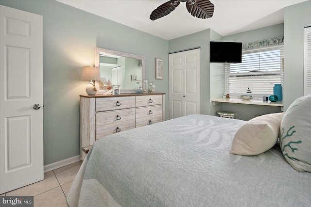 bedroom with a ceiling fan, light tile patterned flooring, and baseboards