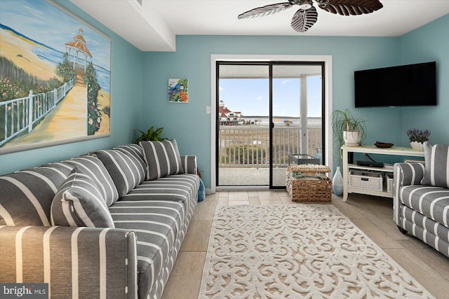 living room with ceiling fan and light wood finished floors