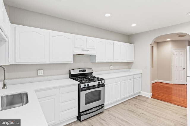 kitchen featuring sink, stainless steel range with gas cooktop, light hardwood / wood-style floors, and white cabinets