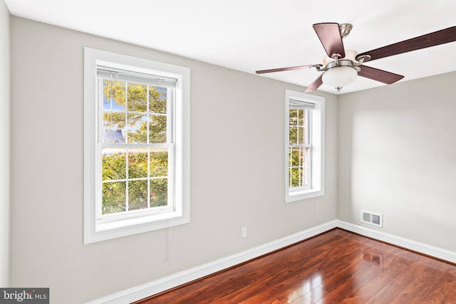 empty room with hardwood / wood-style flooring, ceiling fan, and a wealth of natural light