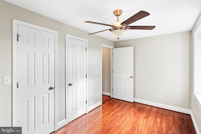 unfurnished bedroom with hardwood / wood-style flooring, ceiling fan, and a closet