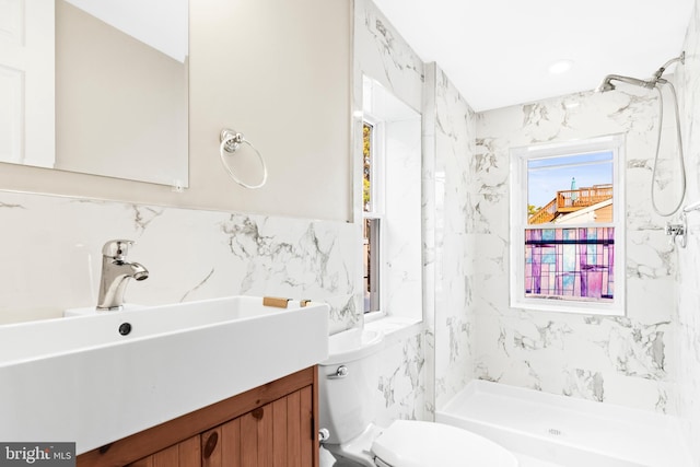 bathroom featuring walk in shower, vanity, toilet, and tile walls