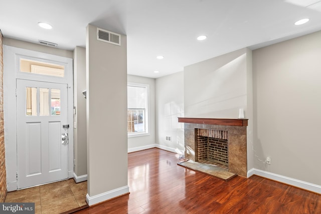 foyer with a fireplace and hardwood / wood-style floors