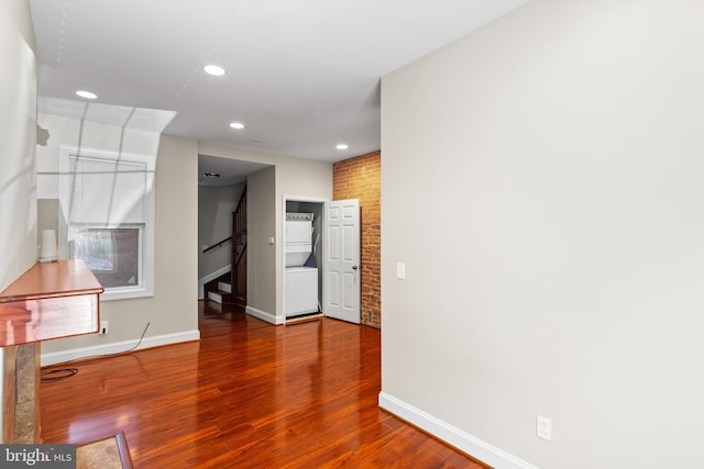 spare room with brick wall and hardwood / wood-style floors