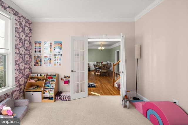 playroom with ornamental molding, french doors, a notable chandelier, and a healthy amount of sunlight