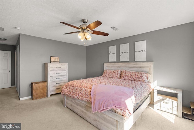 bedroom with light carpet, baseboards, visible vents, and a textured ceiling