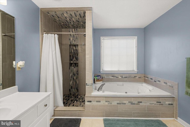 bathroom featuring a tub with jets, a stall shower, vanity, and tile patterned floors