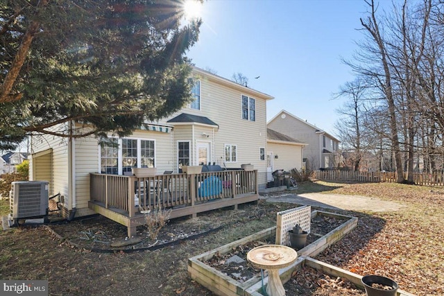 rear view of house with a garden, central AC, fence, and a deck