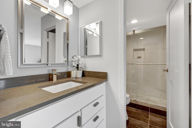 bathroom featuring vanity, toilet, and walk in shower