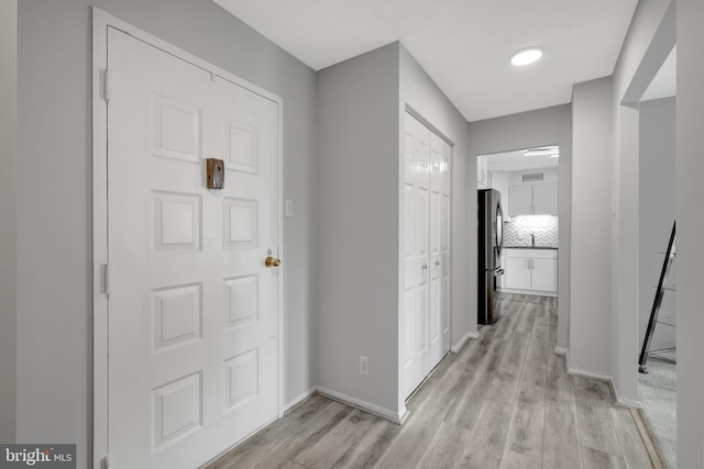 foyer featuring light wood-type flooring and sink