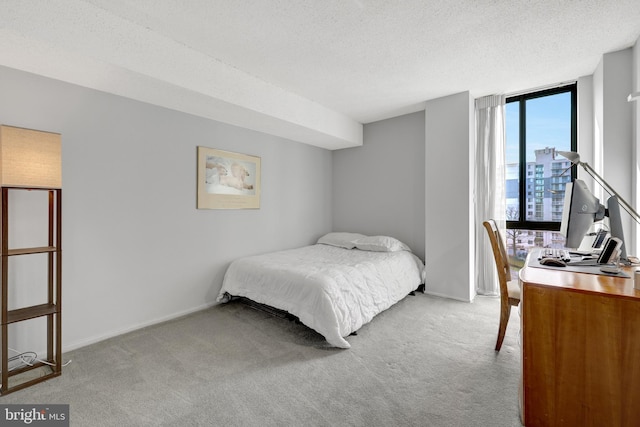 carpeted bedroom featuring expansive windows and a textured ceiling