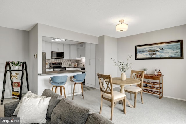 dining area featuring sink and light colored carpet