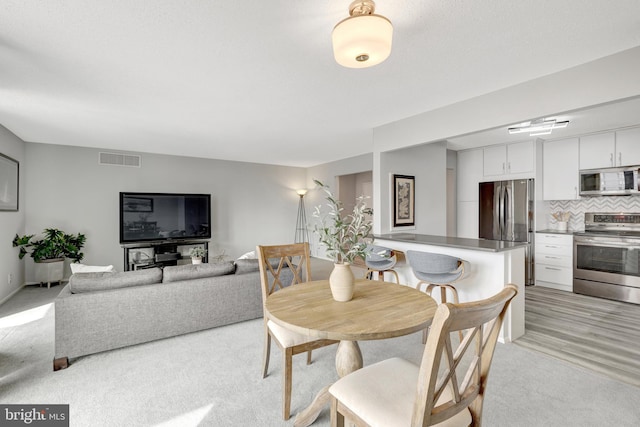 dining area featuring light colored carpet