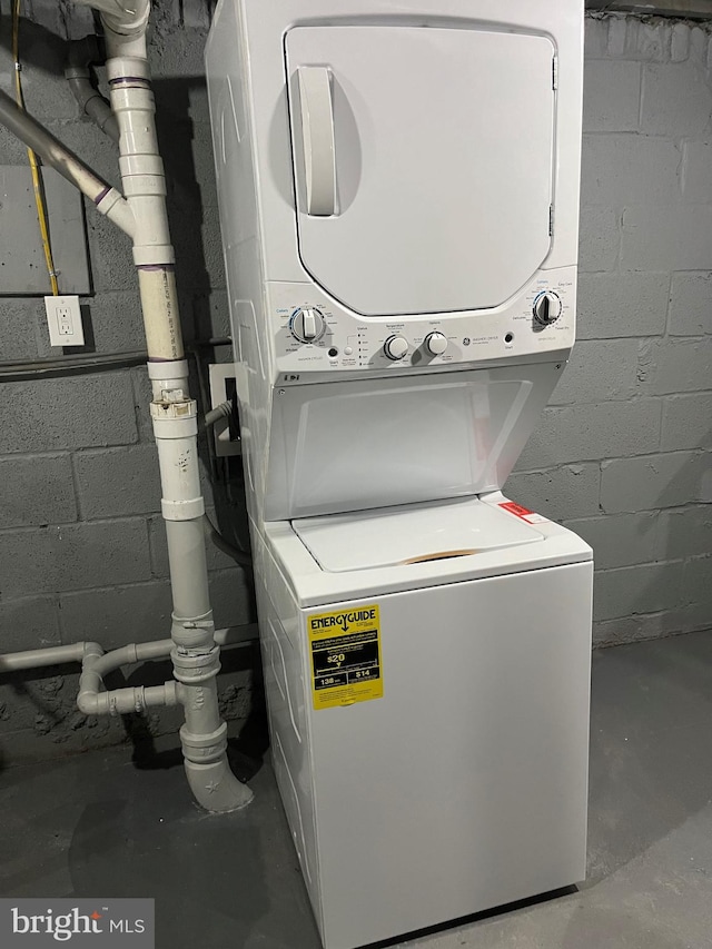 washroom featuring stacked washer and clothes dryer