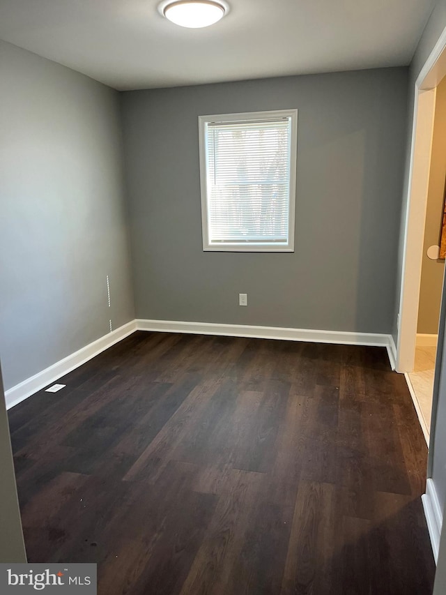 spare room with dark wood-type flooring